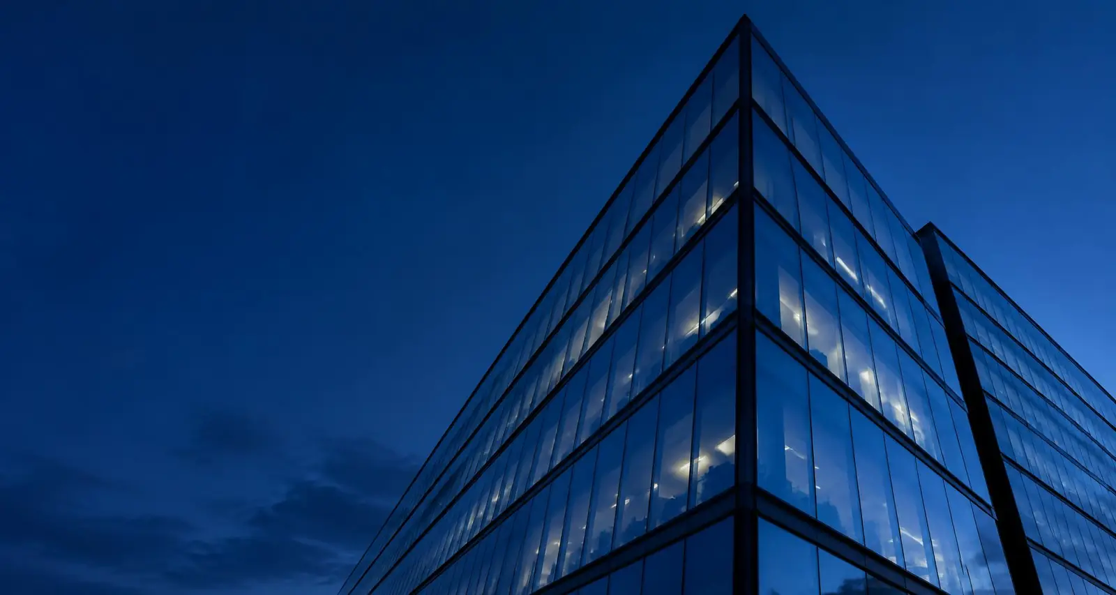 Geometric glass office architecture against a cobalt blue sky